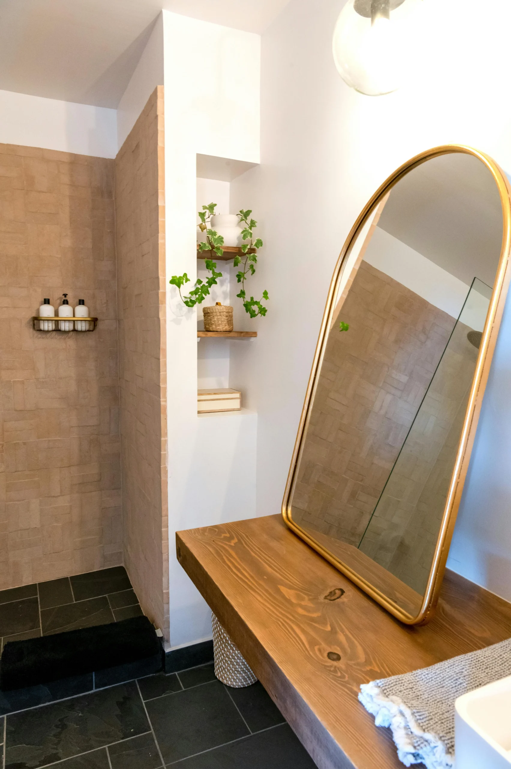 Espejo dorado y madera natural en Baño cálido