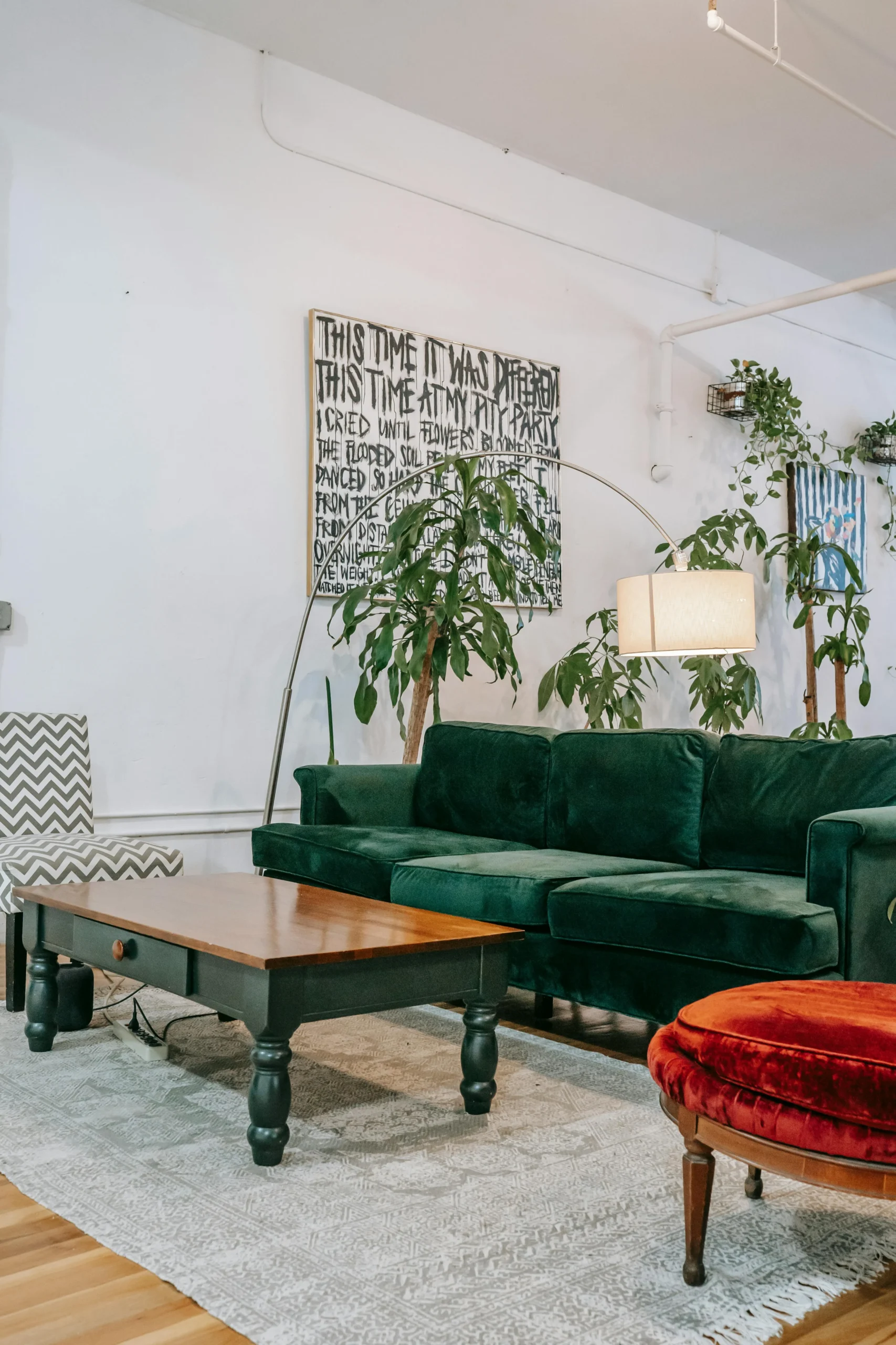 Sala ecléctica con sofá verde y composición de arte tipográfico