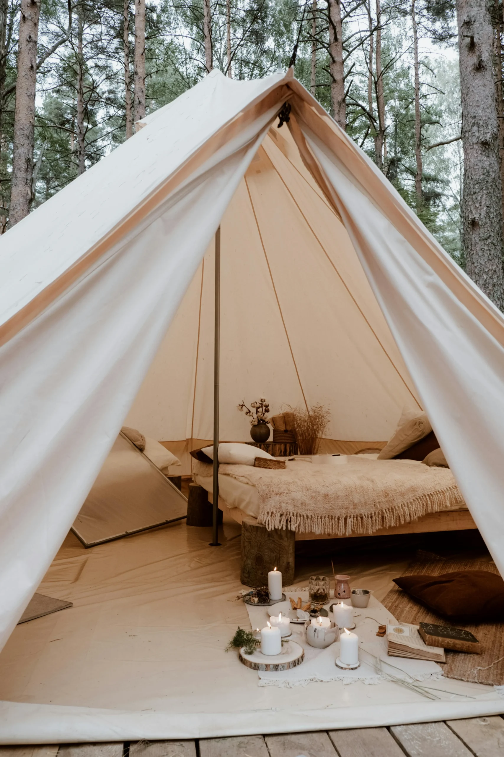Tienda glamping rústica con cama de lino y velas