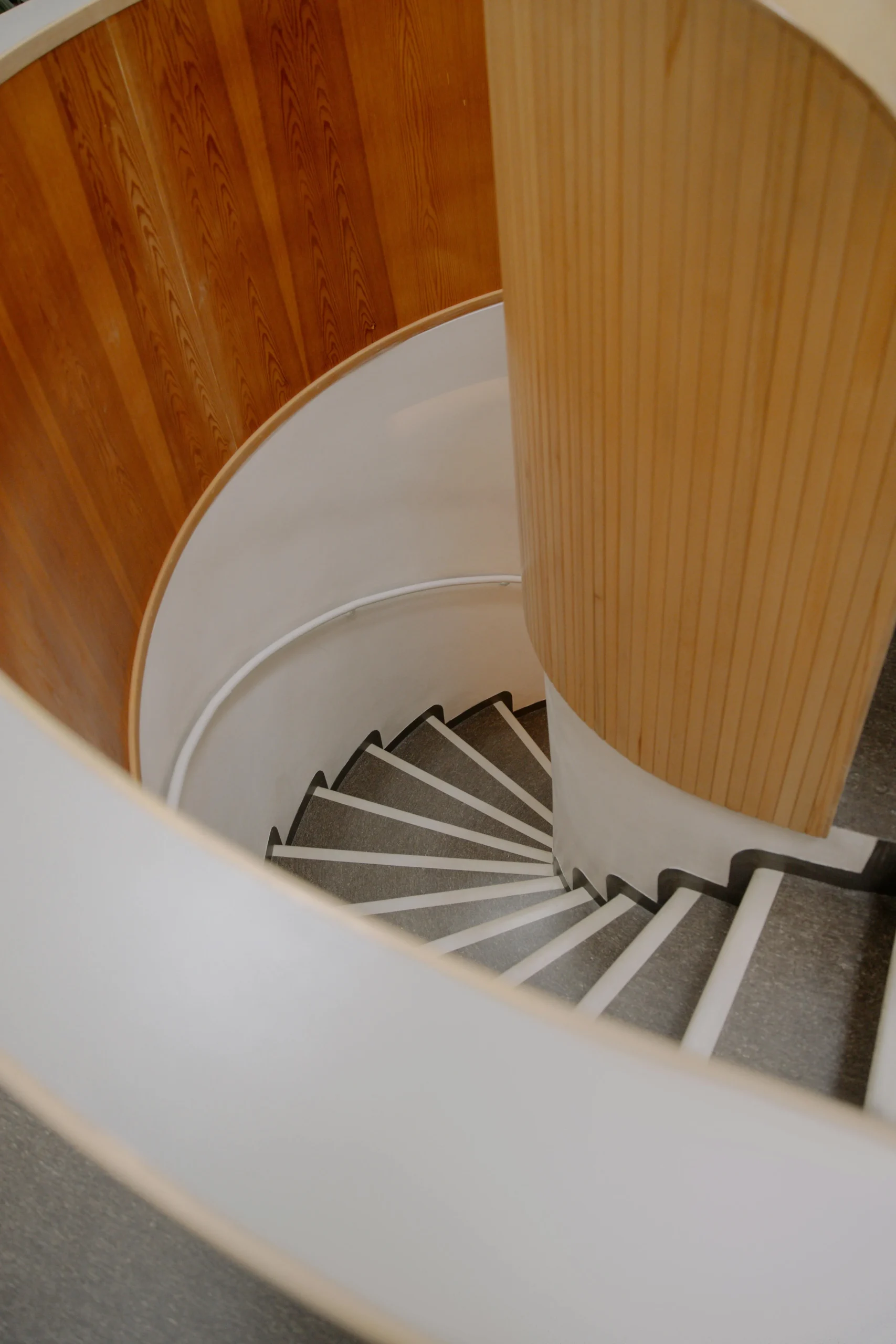 Escalera de caracol con formas orgánicas y revestimiento en madera clara