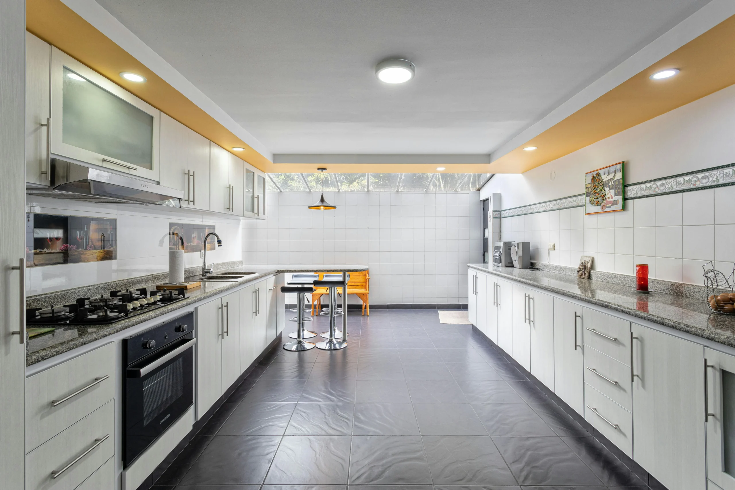 Cocina Lineal Blanca con Toques Modernos y Encimeras de Granito