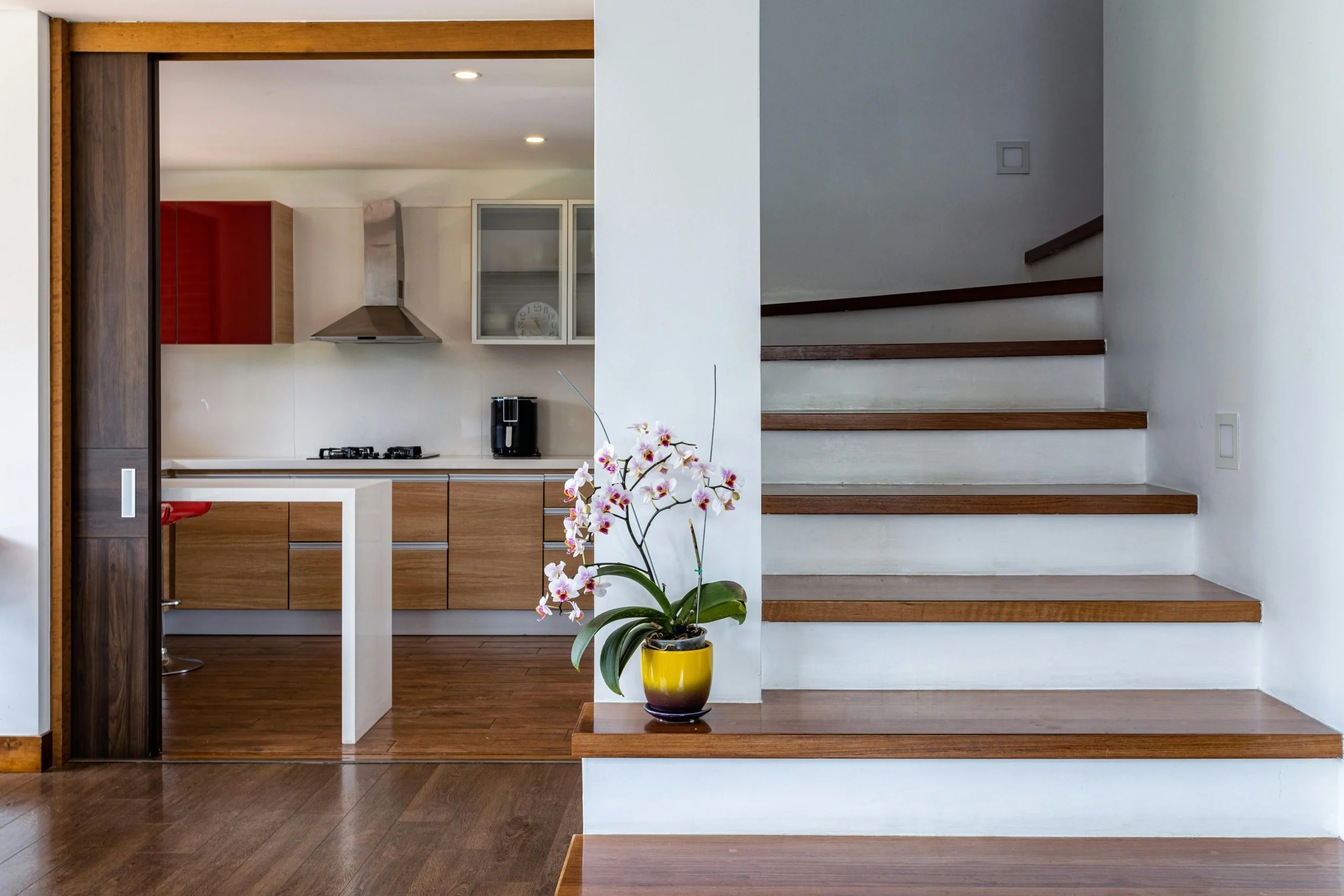 Cocina Abierta con Detalles en Madera y Escalera Moderna