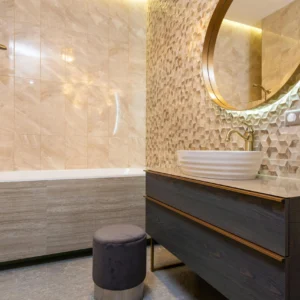 Baño Elegante con Revestimiento Texturizado y Grifería Dorada