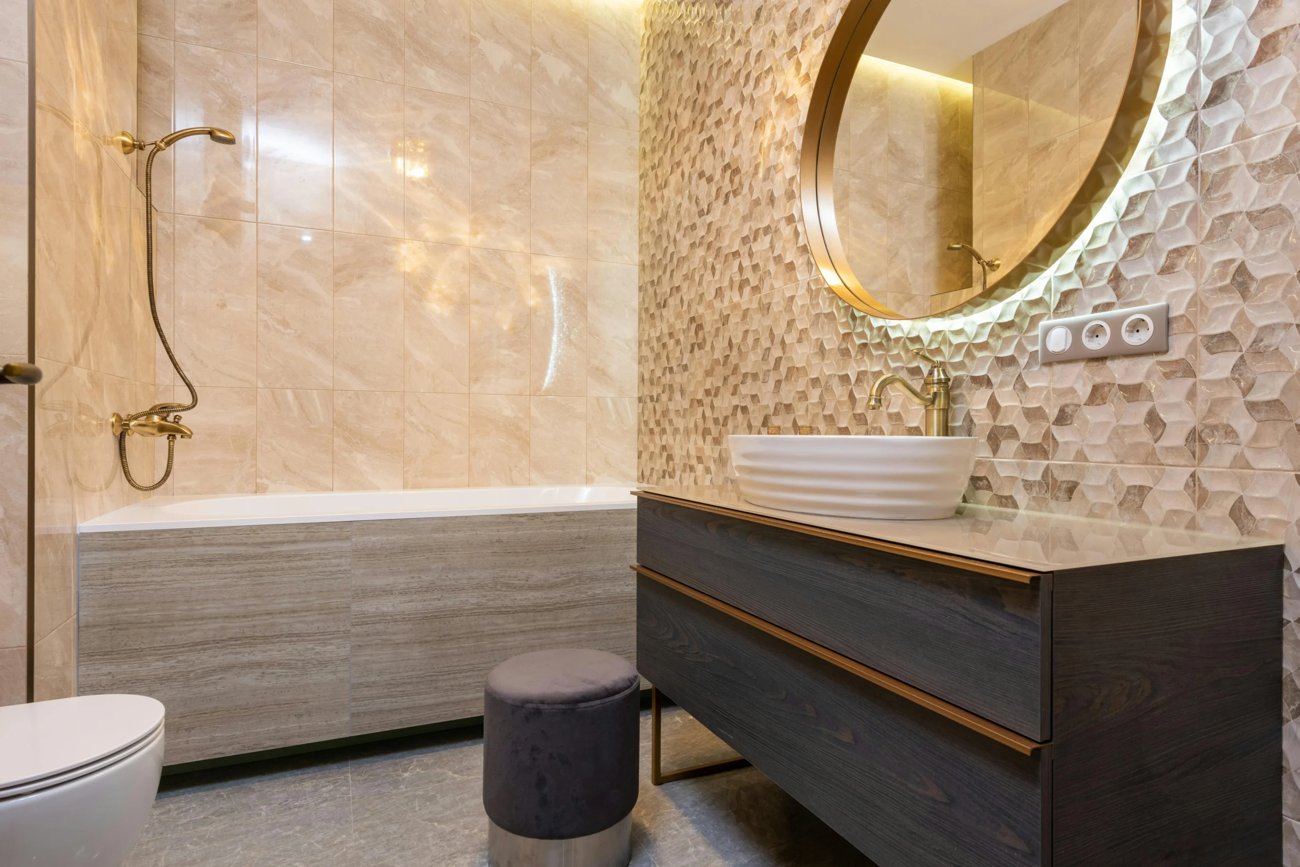 Baño Elegante con Revestimiento Texturizado y Grifería Dorada