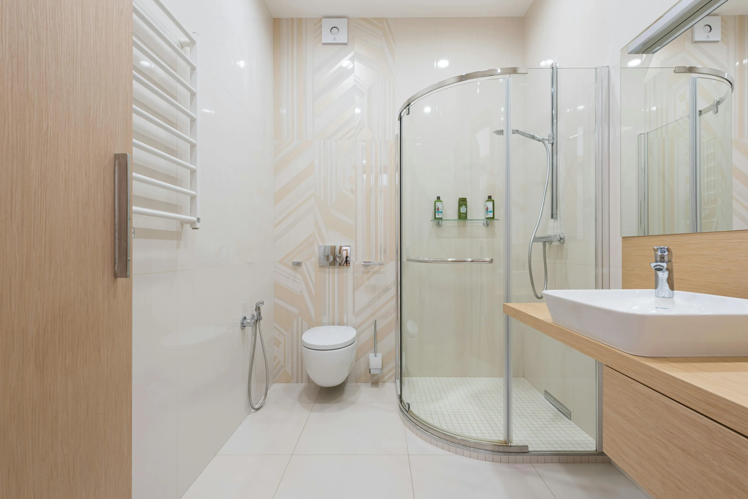 Baño Minimalista en Beige y Blanco con Ducha de Cristal Curva