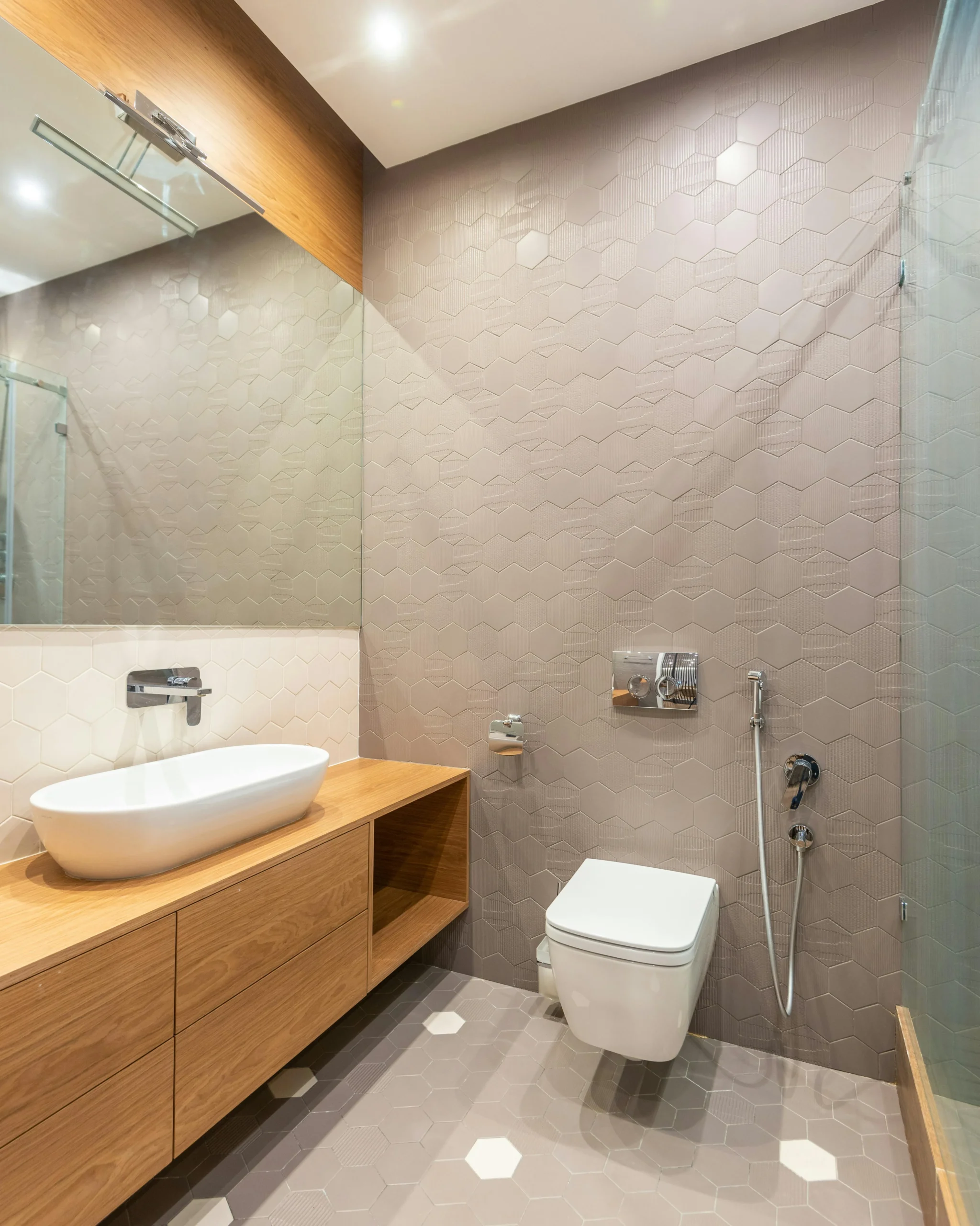 Baño Minimalista con Revestimiento Hexagonal y Madera Clara 