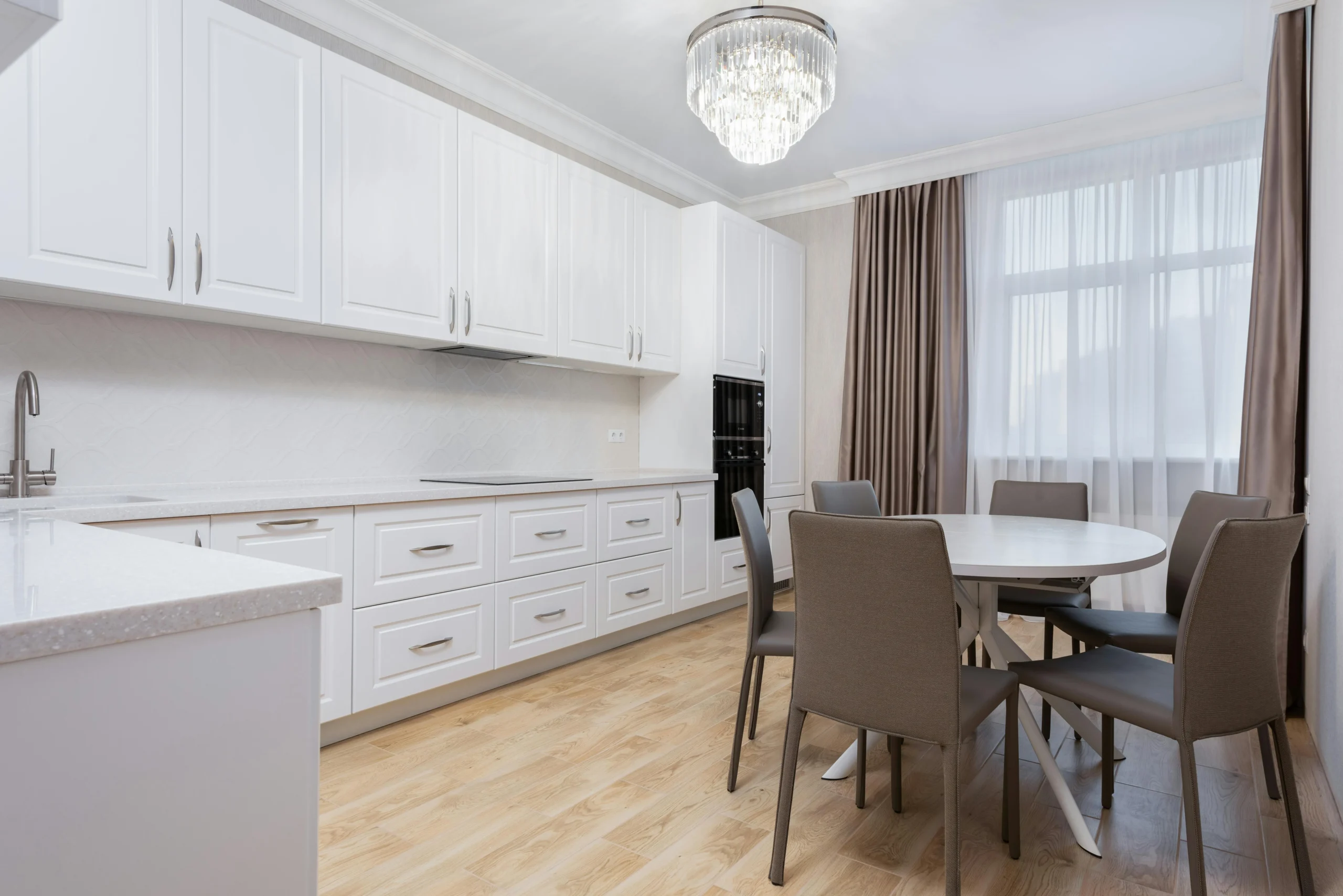 Cocina Blanca Clásica con Mesa Redonda y Suelo de Madera Clara