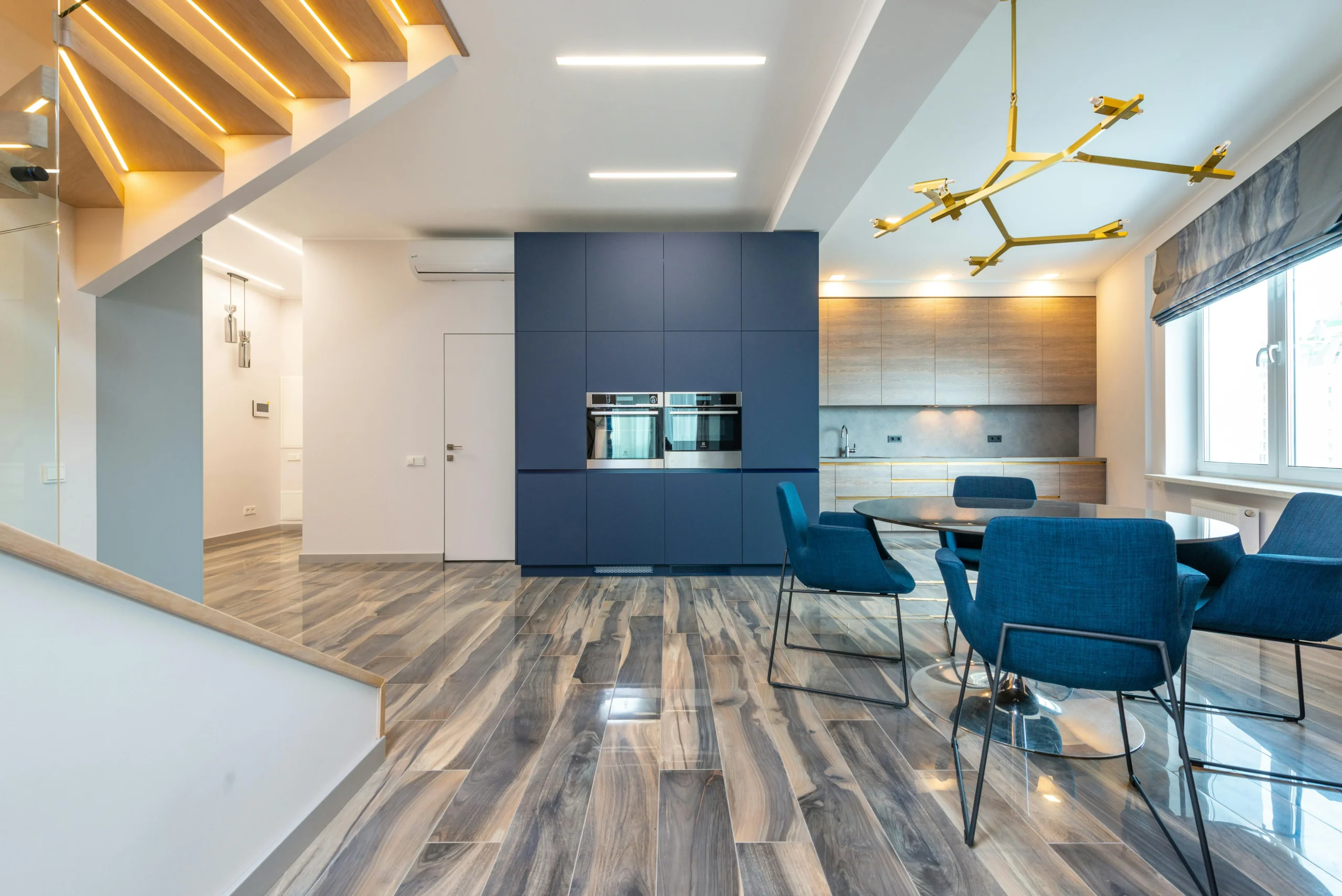 Comedor Moderno con Sillas Azules y Cocina Integrada en Madera y Azul Marino