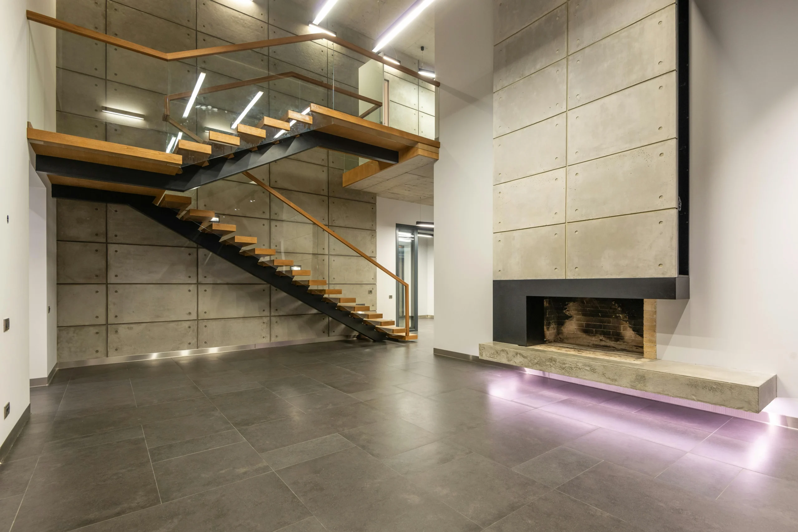 Salón Industrial con Chimenea Suspendida y Escaleras Voladas