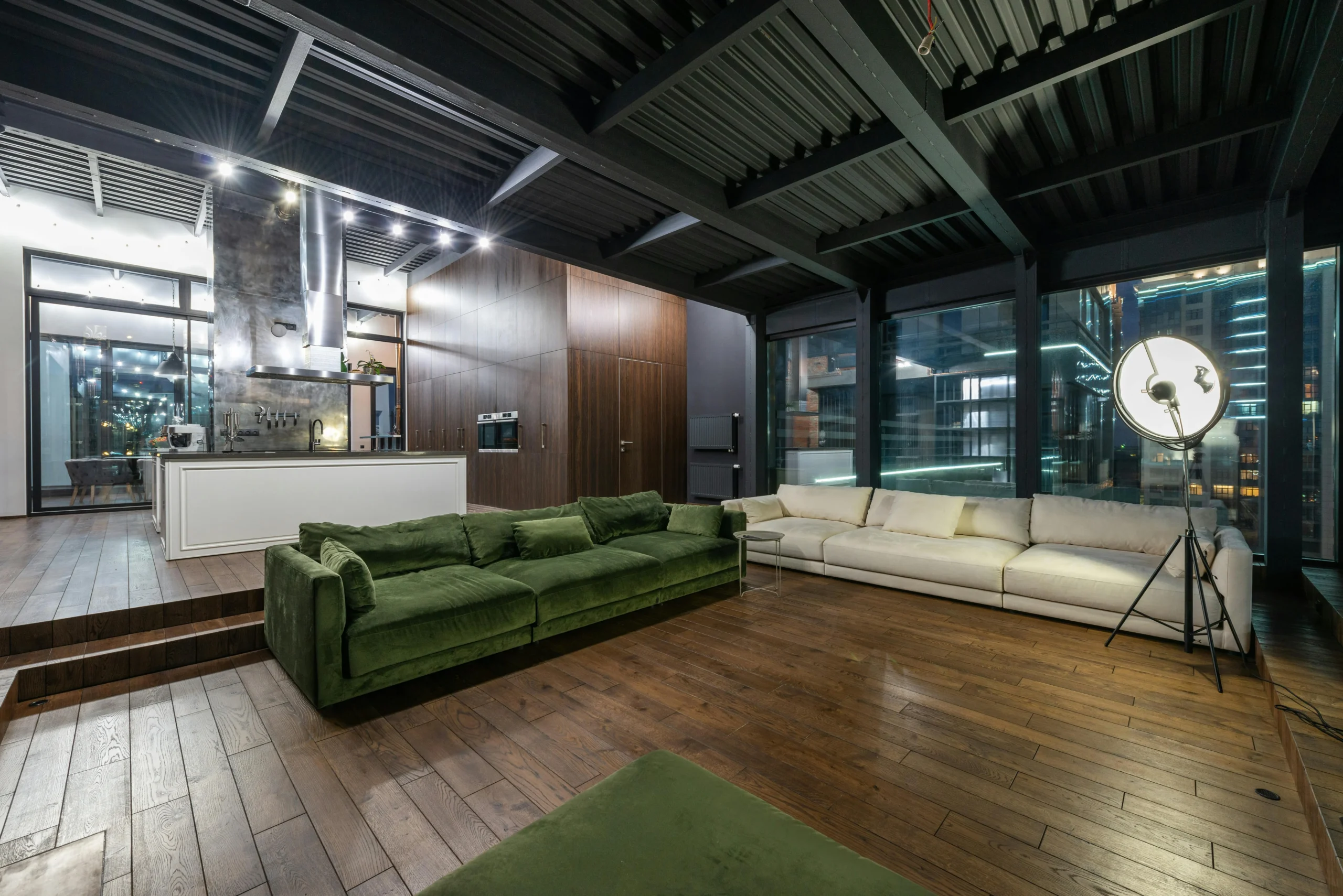 Loft Contemporáneo con Sofás Verdes y Vista Urbana