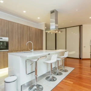 Cocina Contemporánea con Isla Blanca y Madera Oscura