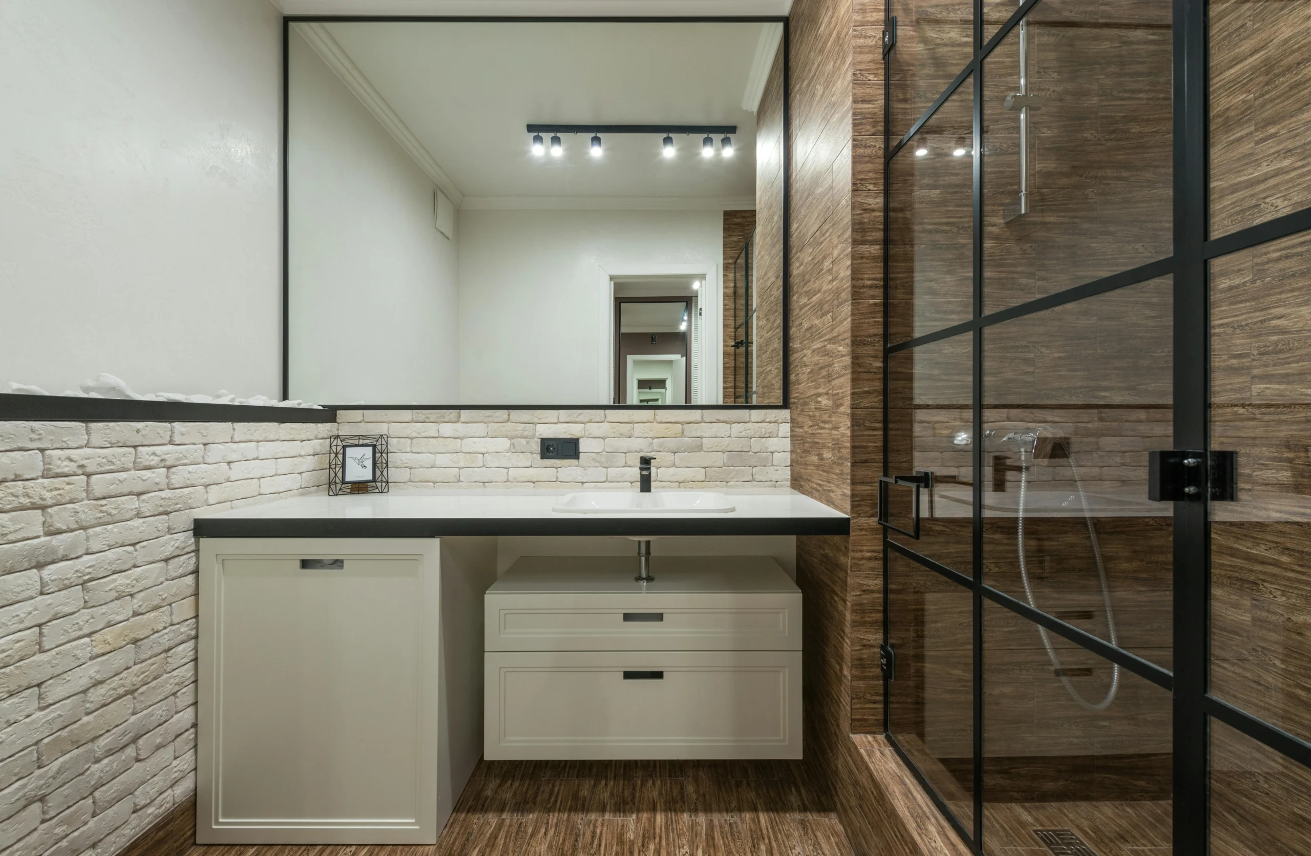 Baño Industrial con Ducha en Vidrio y Acabados en Madera Oscura