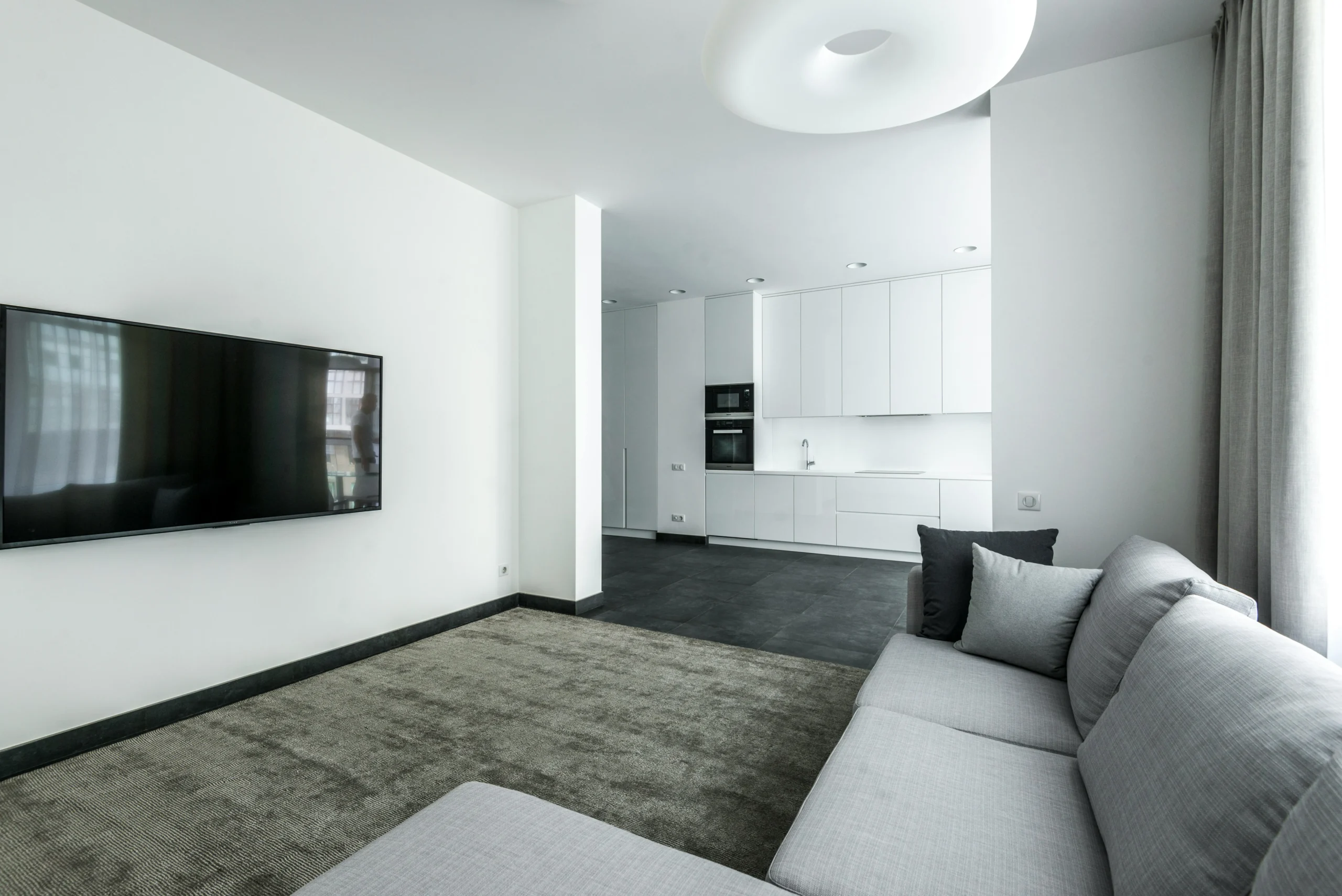 Sala-Comedor Minimalista en Blanco Puro con Sofá Modular Gris