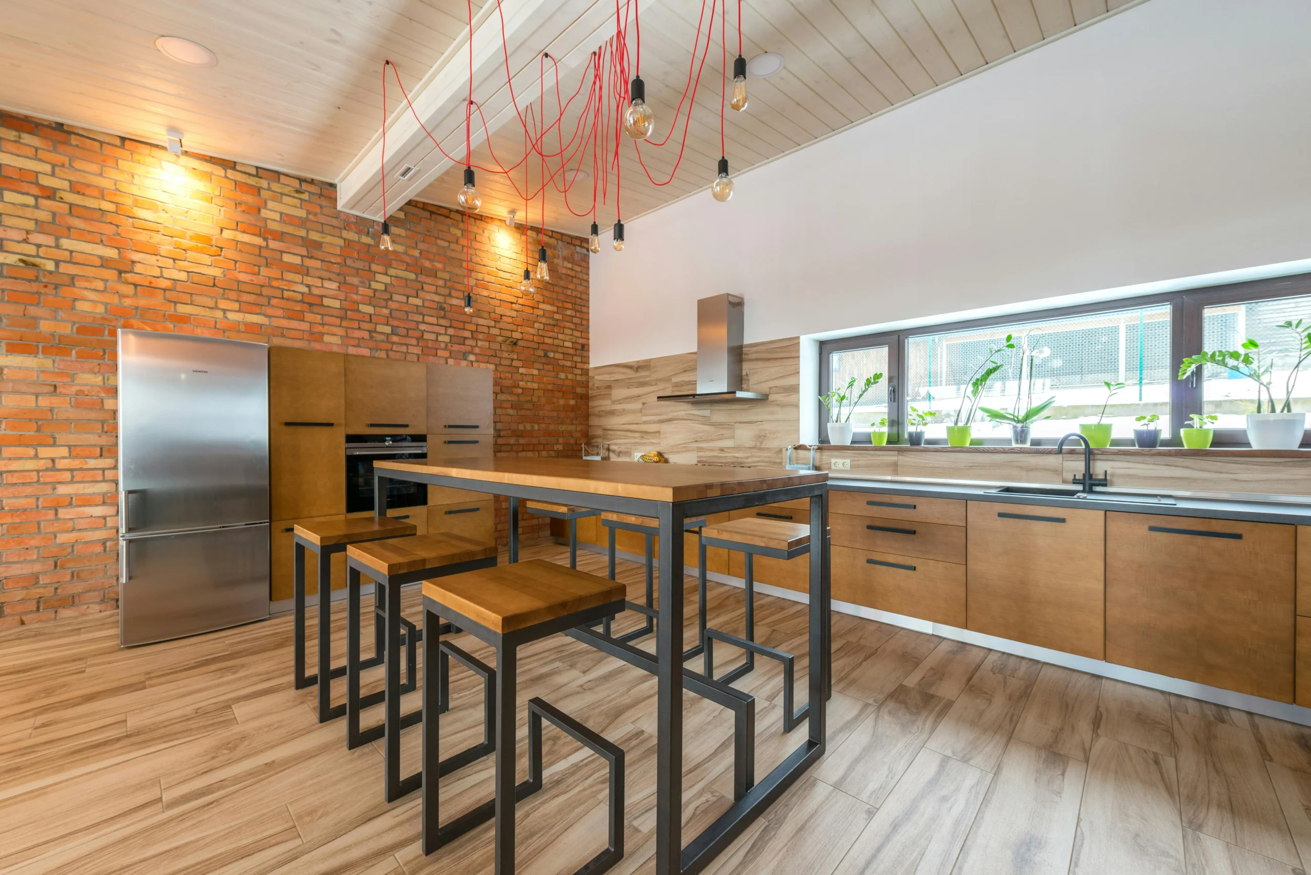 Cocina Industrial con Ladrillo Visto y Barra de Madera Natural