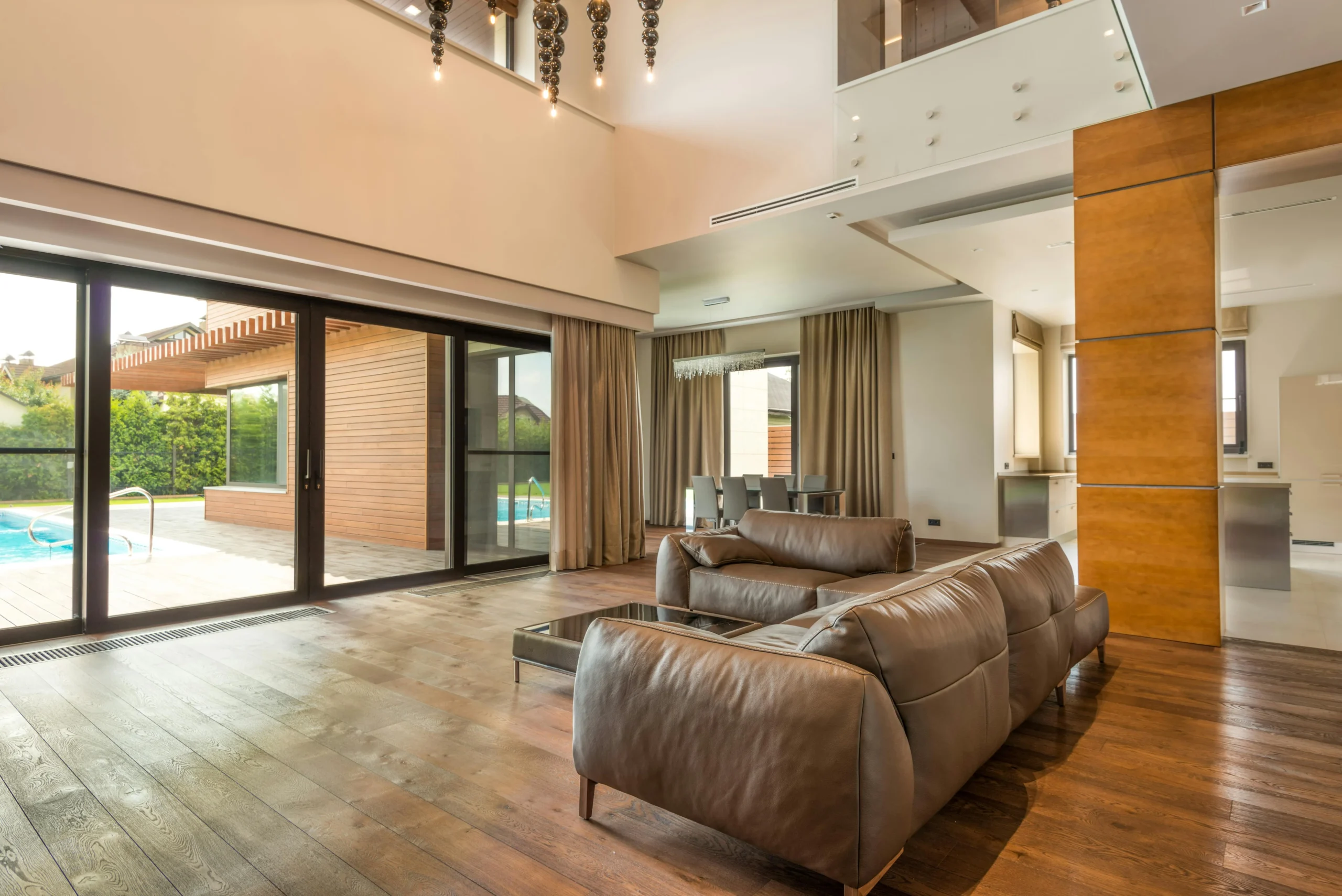 Salón de Doble Altura con Vistas a Piscina y Zona de Comedor