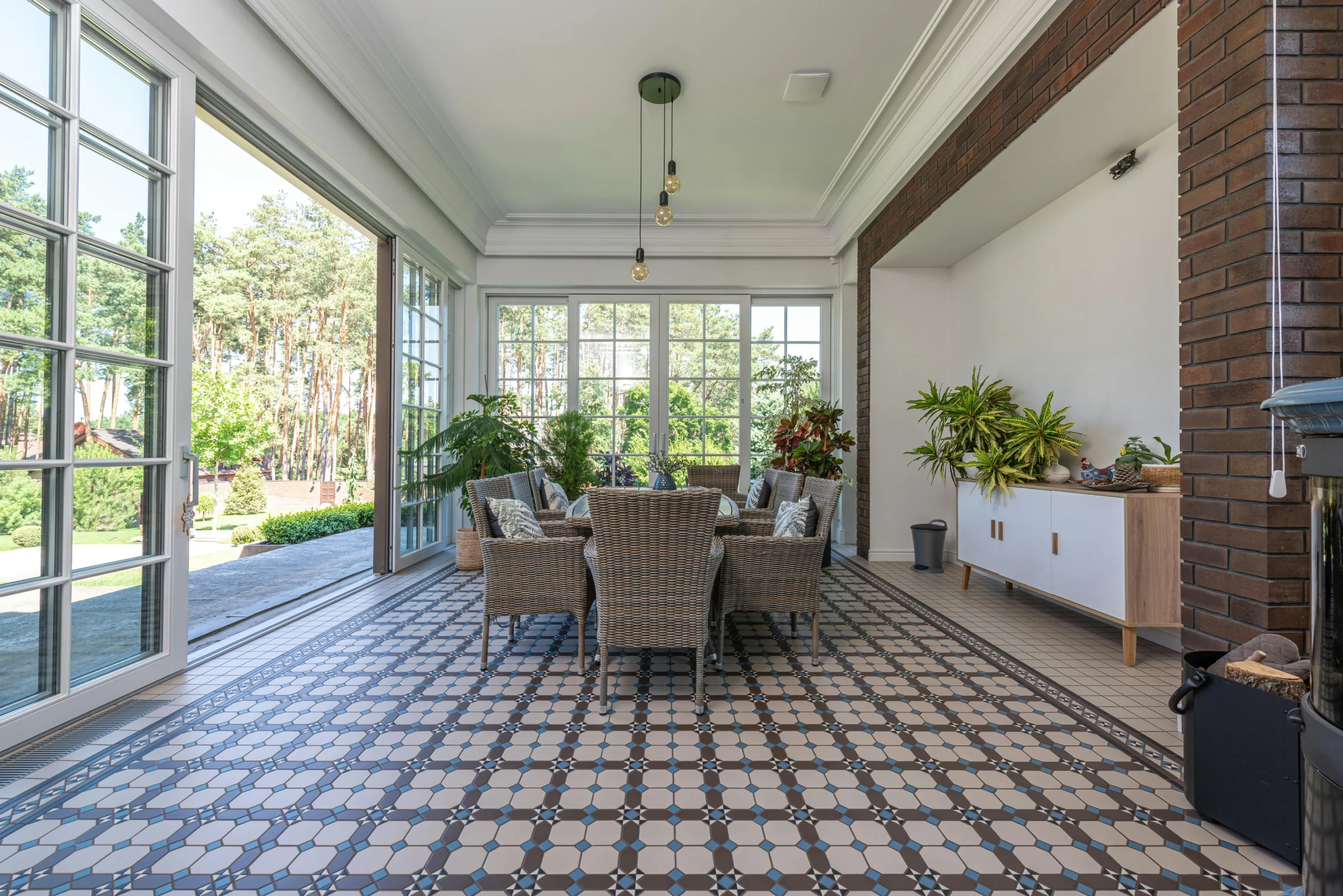 Comedor acristalado con pavimento hidráulico y vistas al jardín