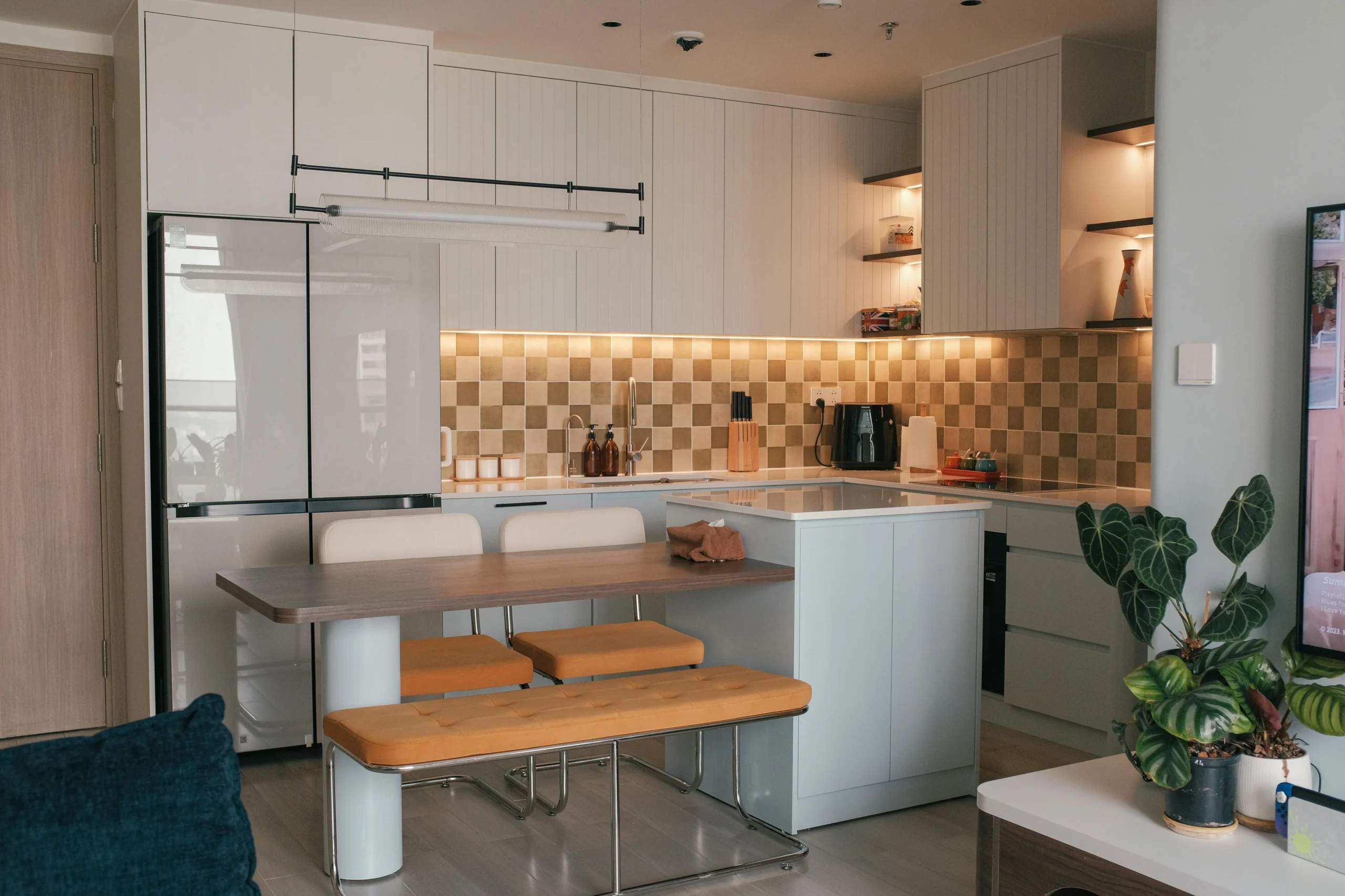 Cocina compacta con mesa integrada y azulejos en damero beige