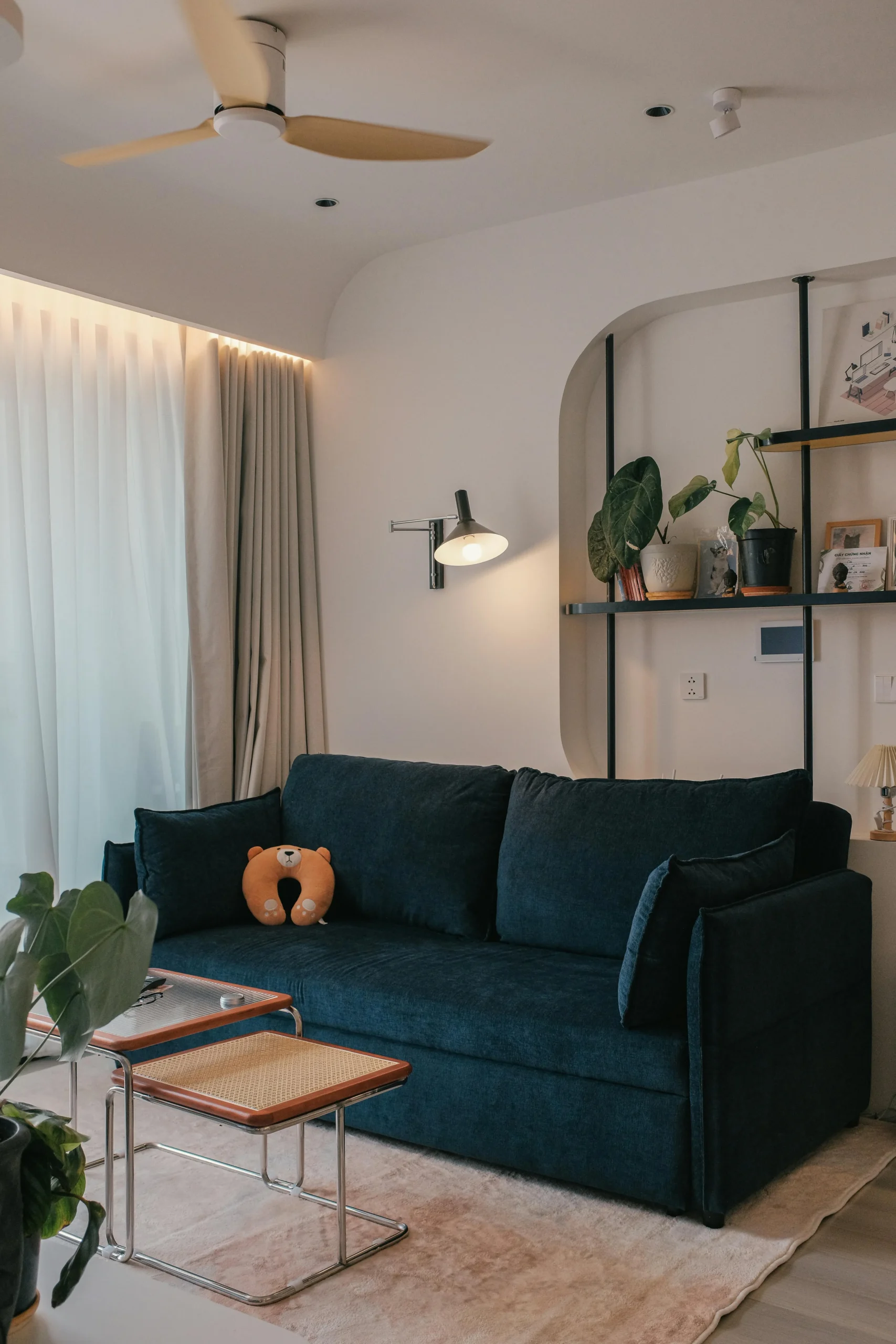 Sala de estar minimalista con sofá azul y luz indirecta