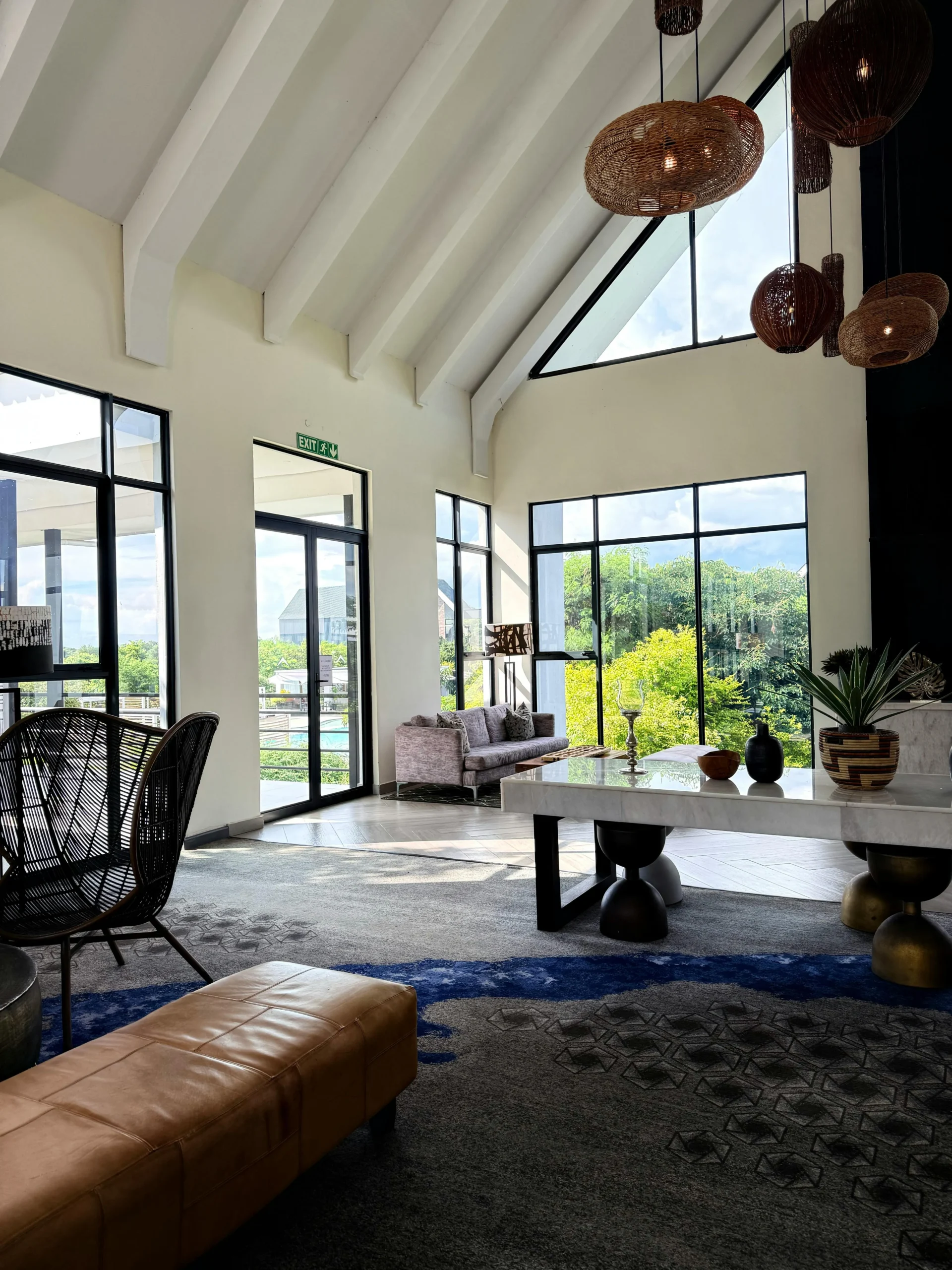 Lobby Contemporáneo con Luminarias de Ratán y Ventanales a Paisaje