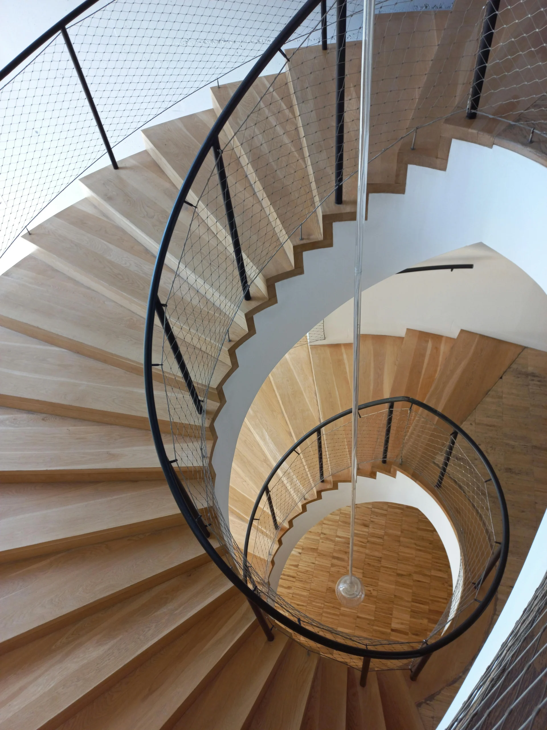 Escalera Helicoidal en Madera Clara con Barandilla Metálica