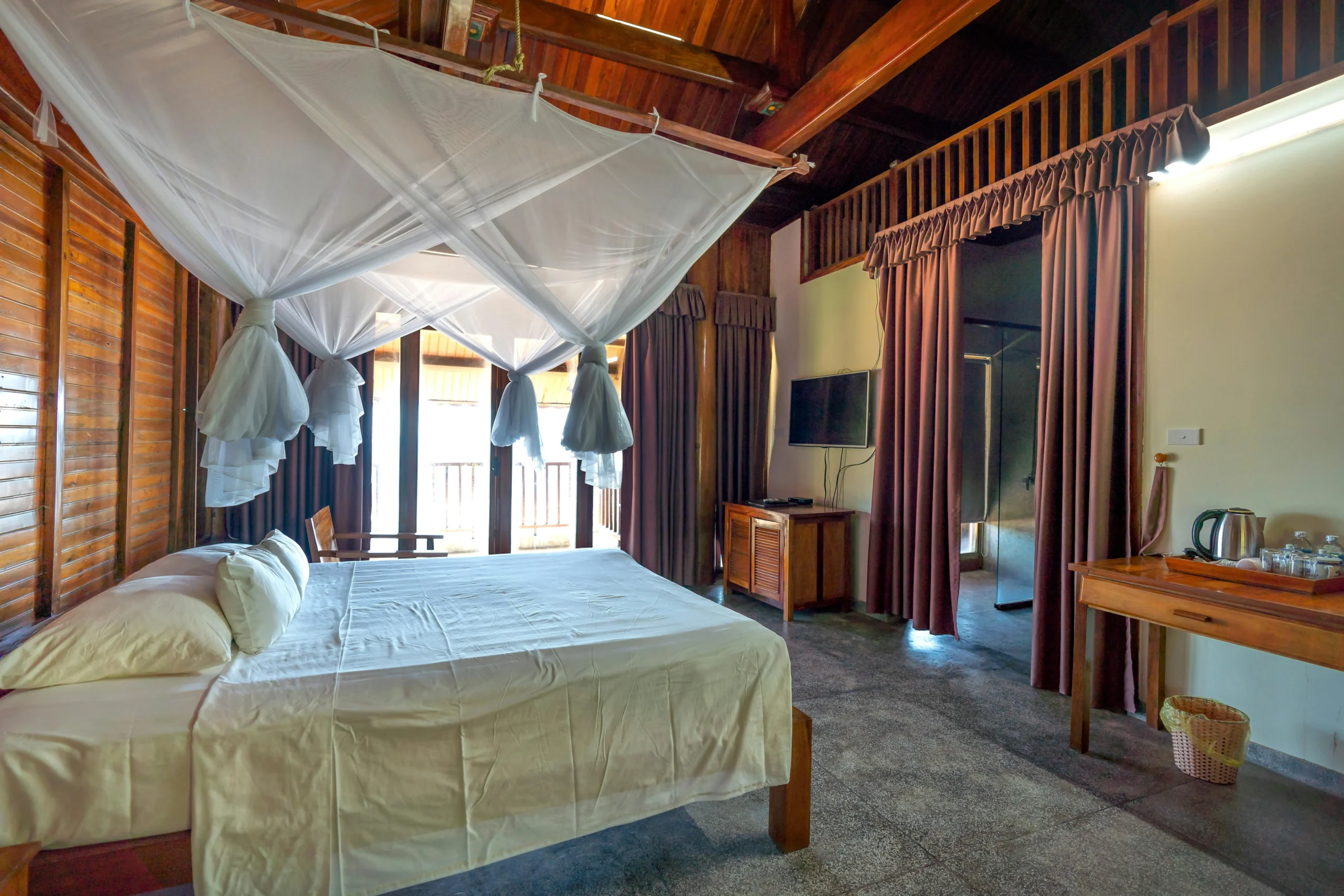 Dormitorio Principal Tropical con Estructura de Madera y Dosel de Tul