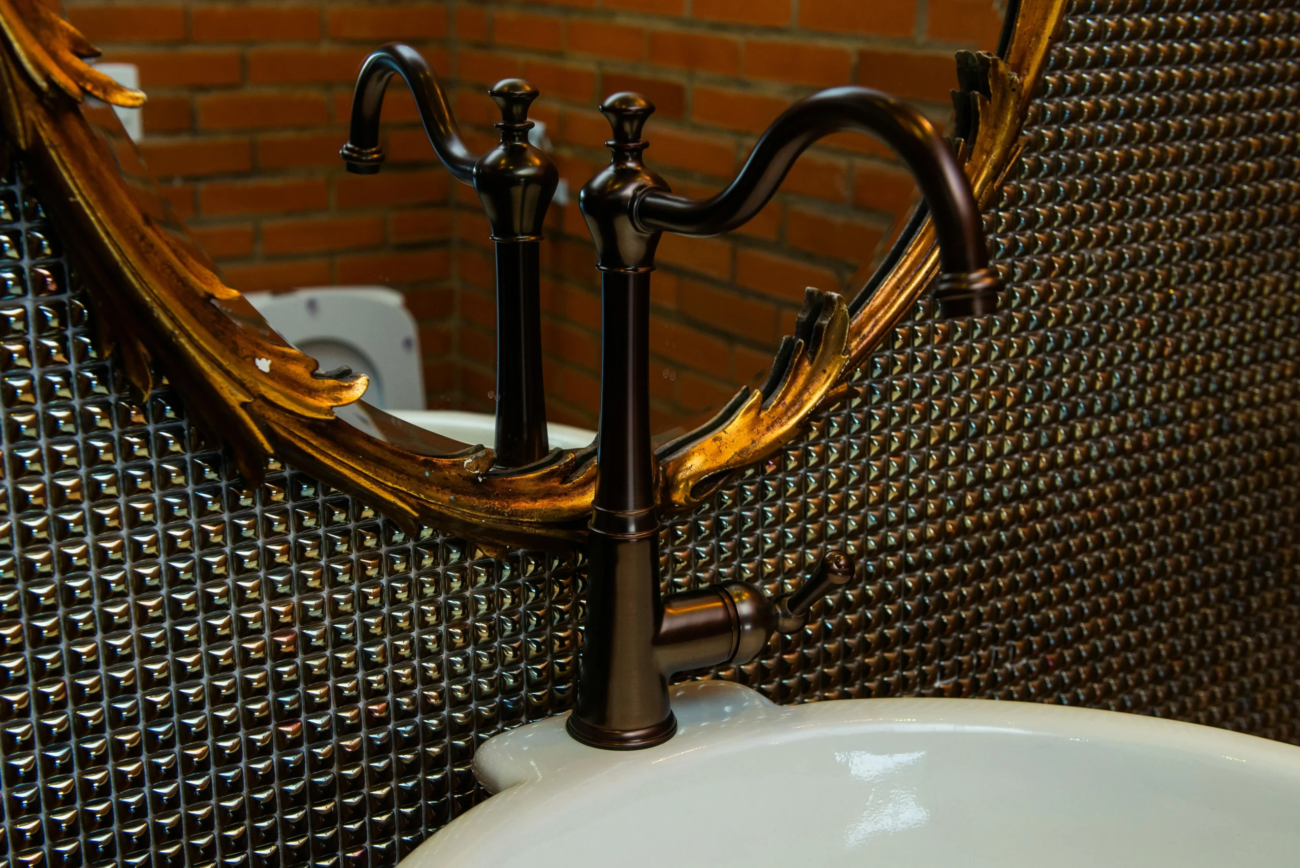 Detalle de Lavabo Clásico con Grifería Negra y Espejo Dorado Barroco