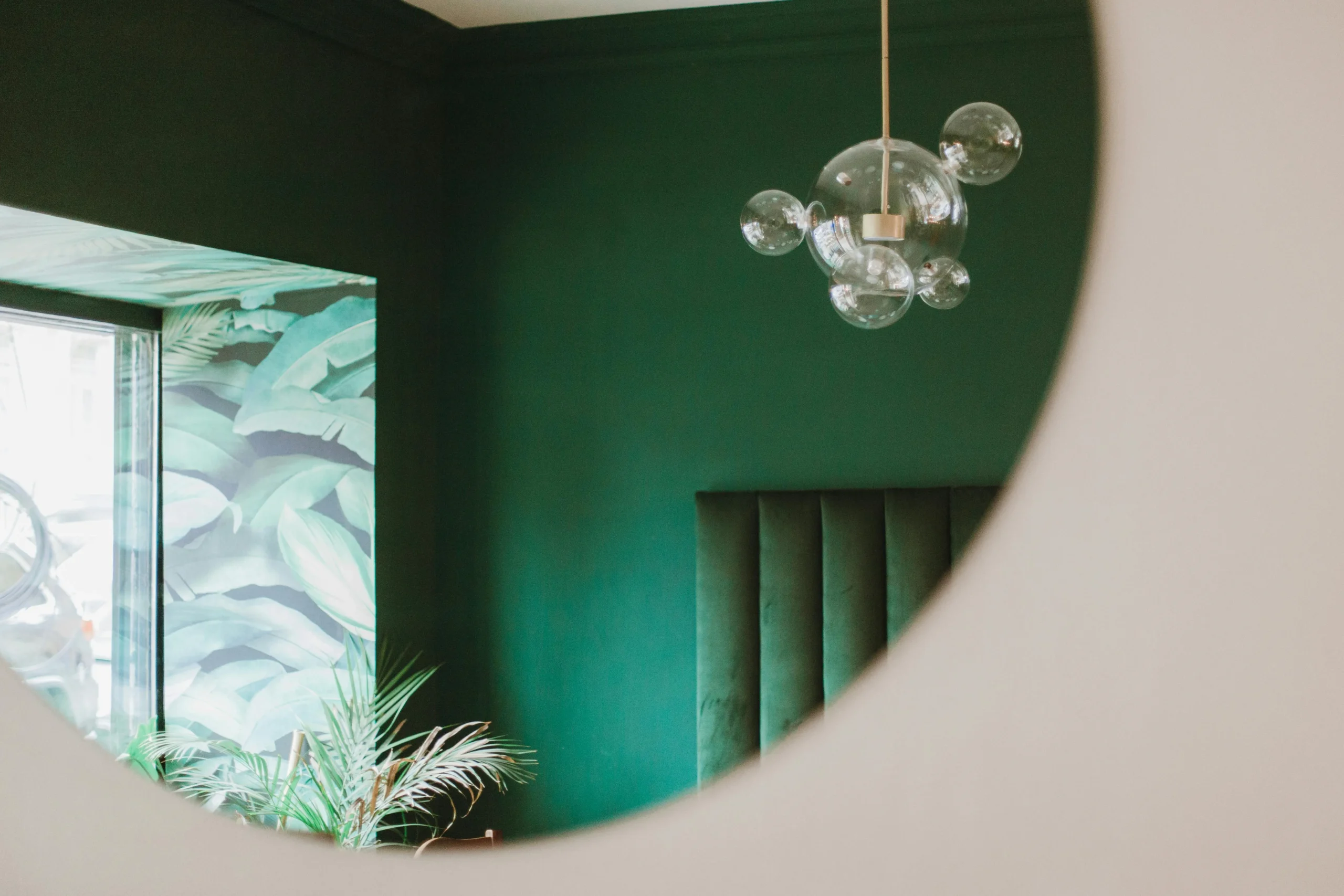 Dormitorio Contemporáneo con Pared Verde y Lámpara Escultural de Vidrio