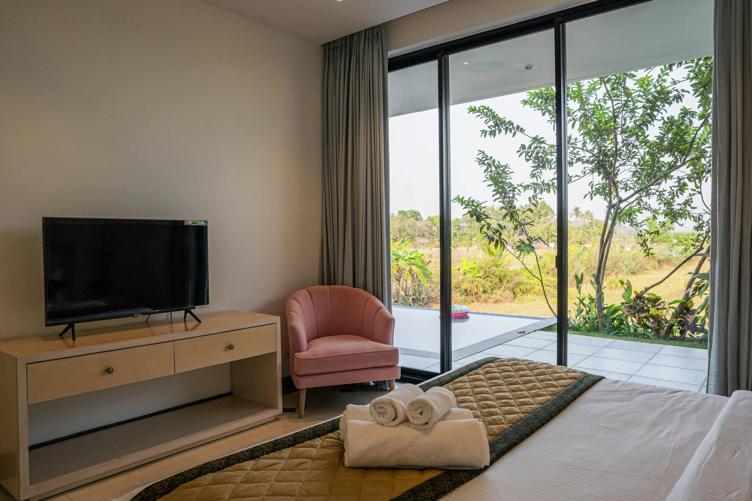 Dormitorio con Vistas al Jardín y Sillón Rosa Empolvado