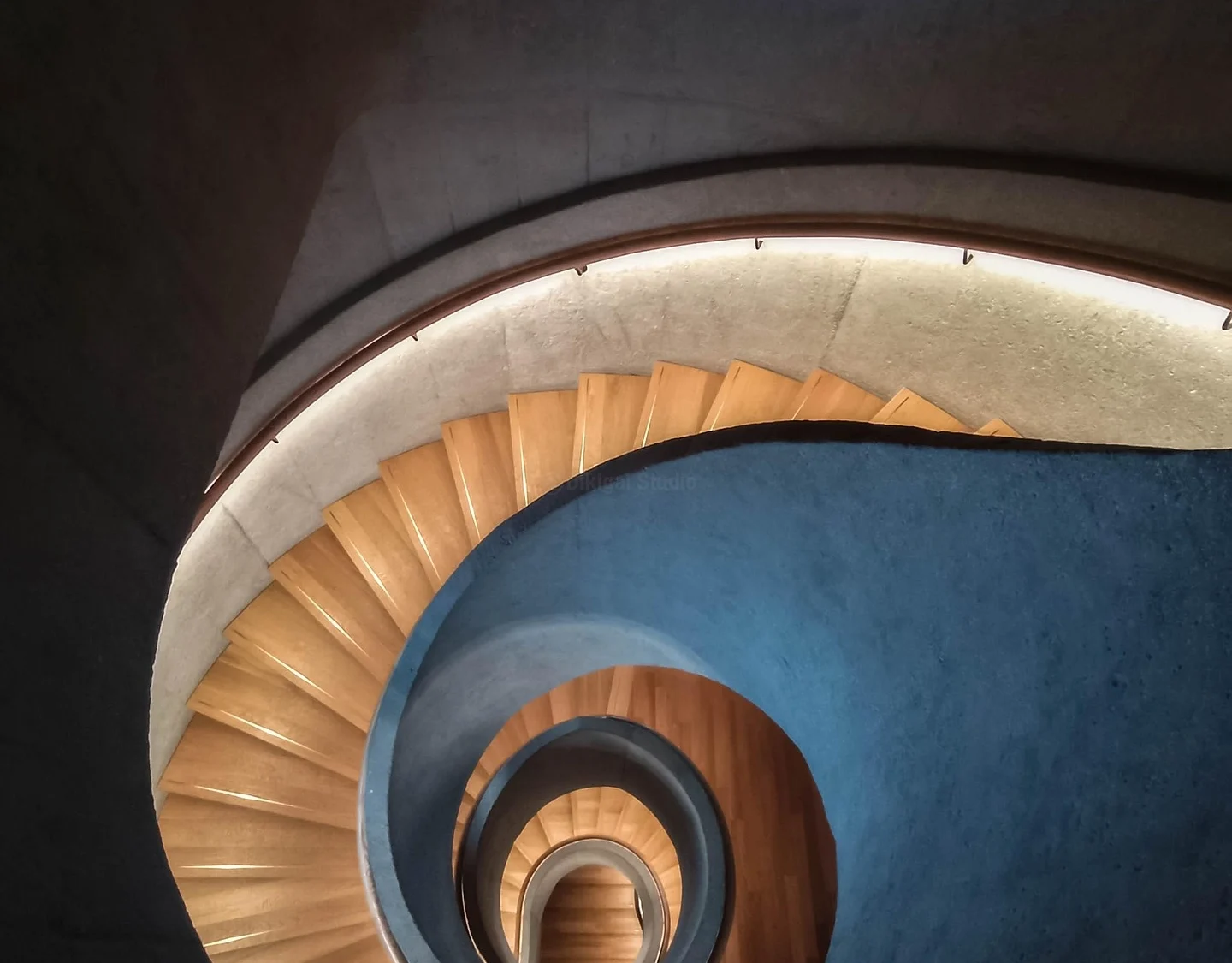 Escalera helicoidal en concreto con iluminación indirecta
