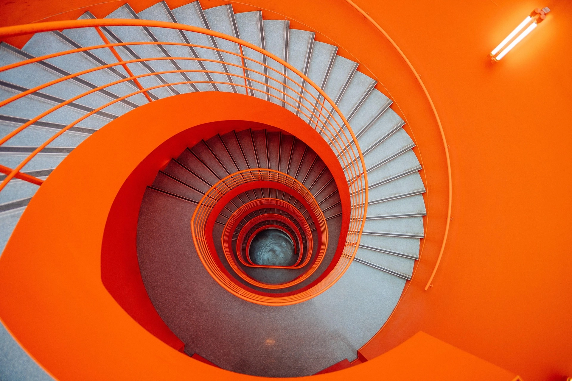Escalera helicoidal interior en naranja vibrante con diseño escultórico