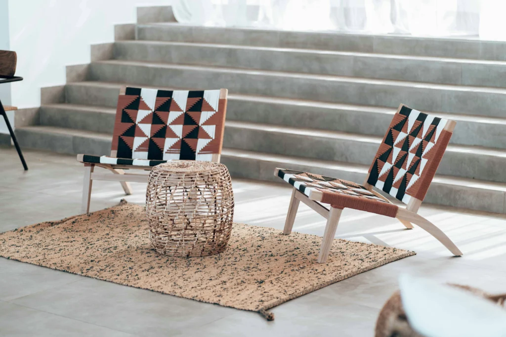 Interiorismo contemporáneo con sillones tejidos y escalera de hormigón