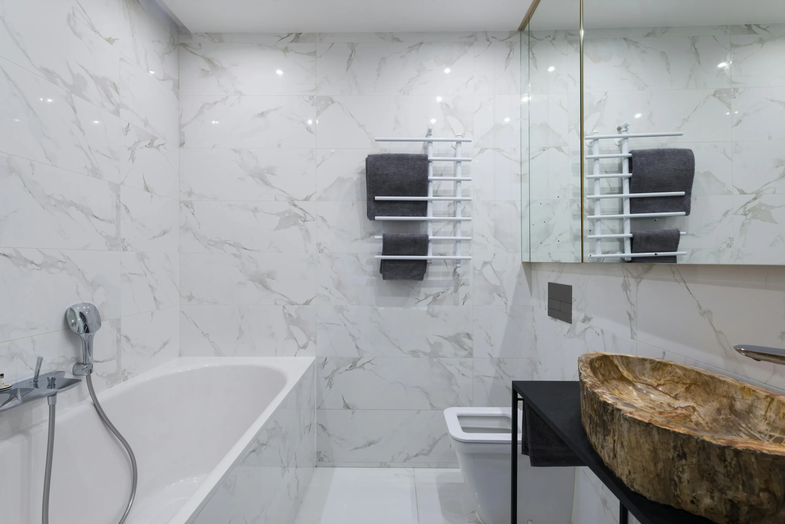 Baño Contemporáneo en Mármol Blanco con Lavabo Escultórico de Piedra Natural