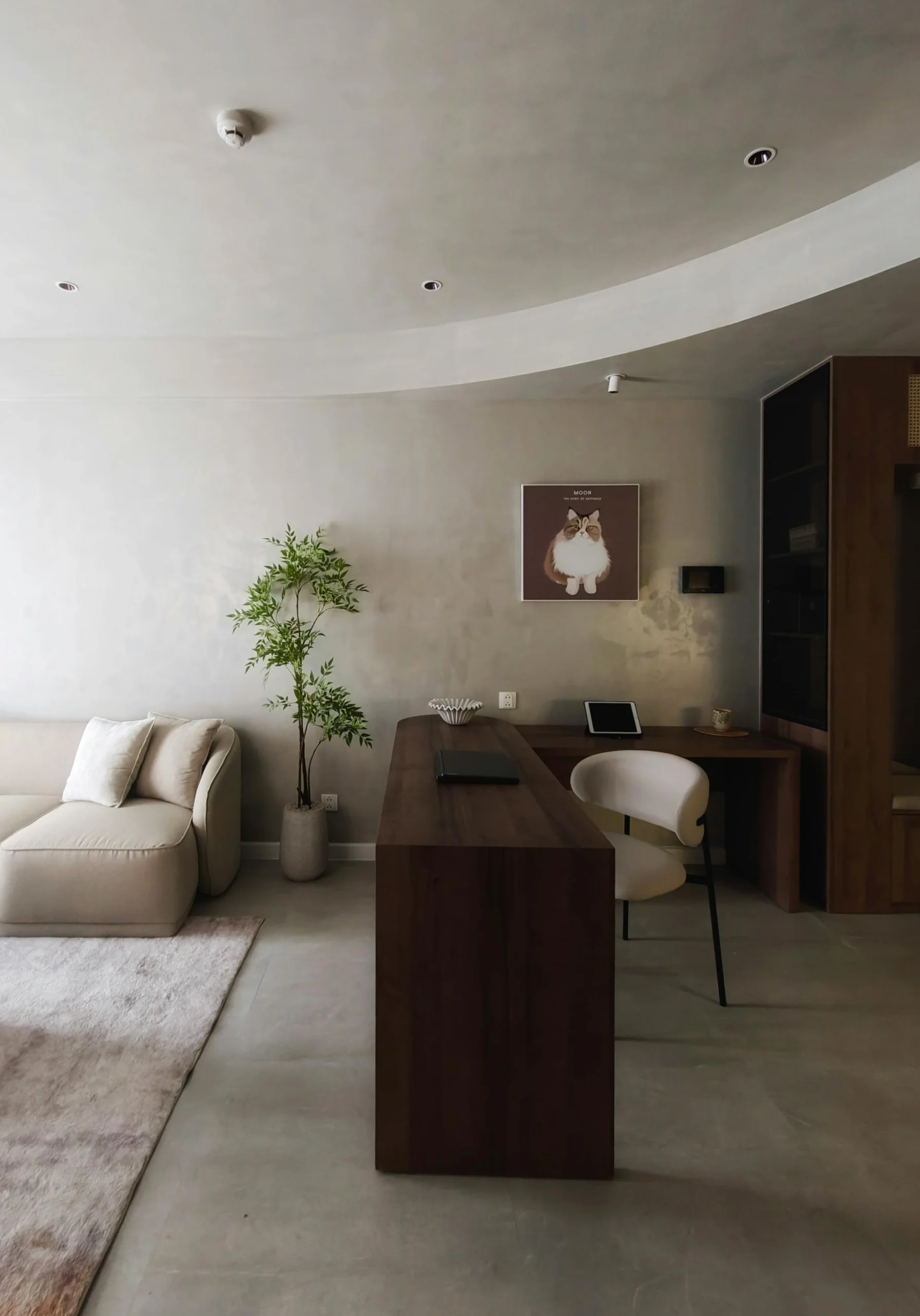 Espacio Multifuncional Minimalista con Pavimento Continuo y Escritorio de Madera Oscura