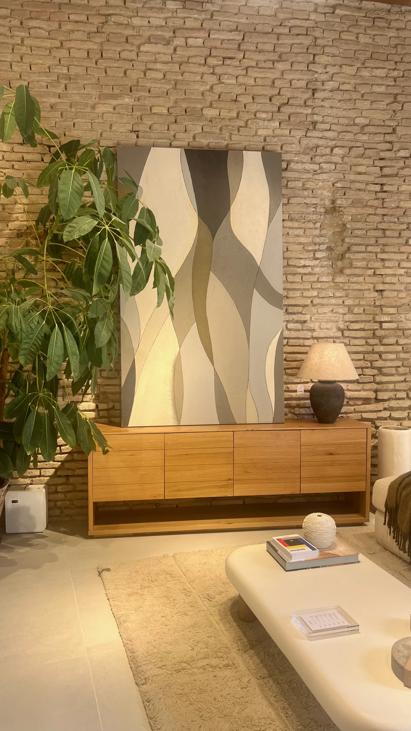 Salón Rústico-Contemporáneo con Aparador de Madera y Muro de Ladrillo Visto