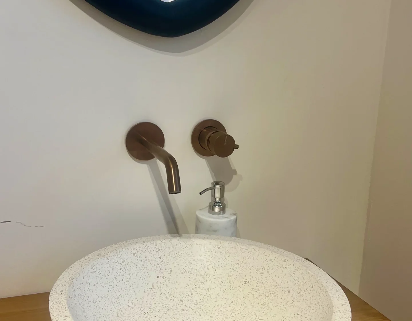 Baño Japandi con Lavabo de Terrazo y Grifería de Cobre Mural