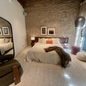 Dikigai Studio_IMG642 Suite Estilo Loft con Pared de Ladrillo Visto y Mobiliario de Madera Oscura