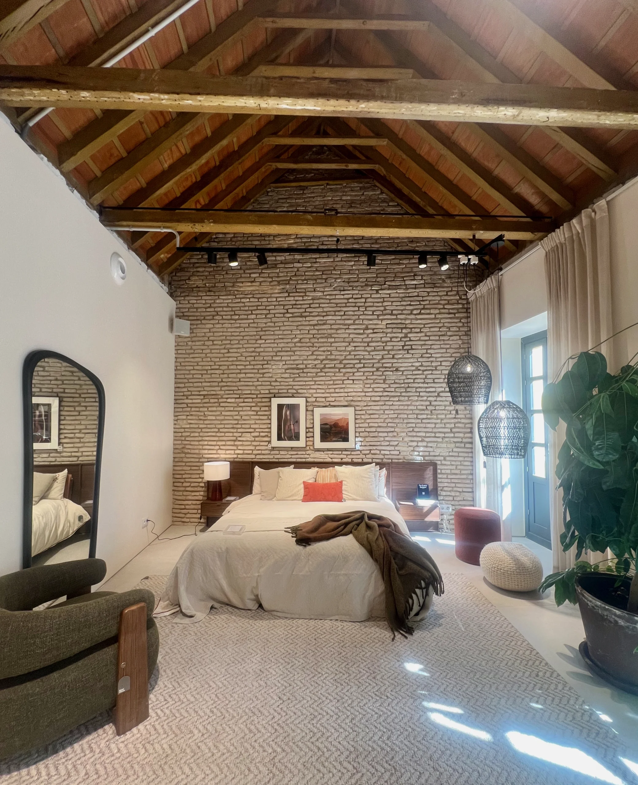 Suite Principal Estilo Loft con Techo de Vigas y Pared de Ladrillo Visto