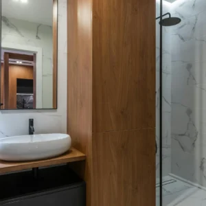 Baño con Mármol Blanco, Mueble Negro y Madera
